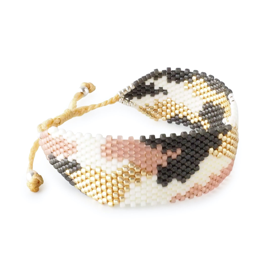 
Pastel animal print Miyuki bead bracelet in soft pink, white, gold, and grey tones. Handmade Colombian artisan jewelry, adjustable cuff.