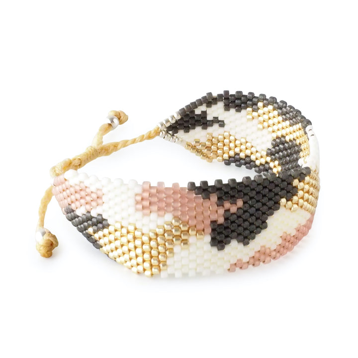 
Pastel animal print Miyuki bead bracelet in soft pink, white, gold, and grey tones. Handmade Colombian artisan jewelry, adjustable cuff.