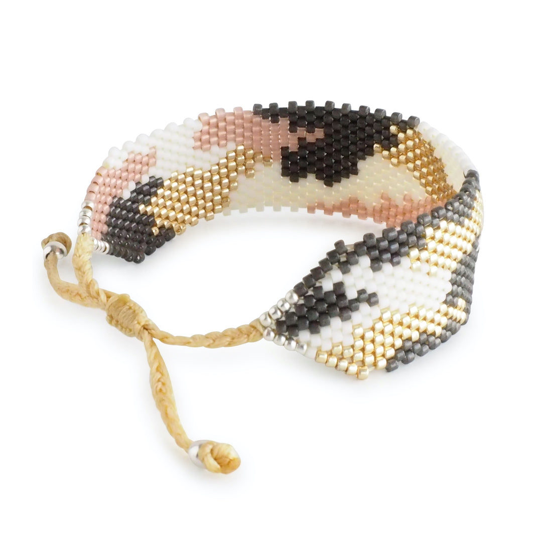Pastel animal print Miyuki bead bracelet in soft pink, white, gold, and grey tones. Handmade Colombian artisan jewelry, adjustable cuff.