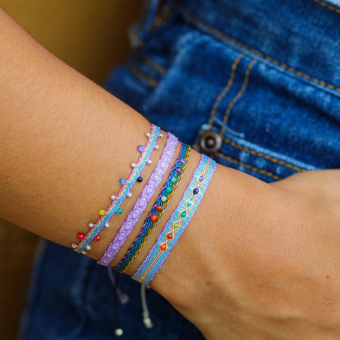 Egyptian Loom Wellness Chakra Bracelet. Made with 80 polyester threads with 7 gemstones representing each chakra. Adjustable Bracelet on model