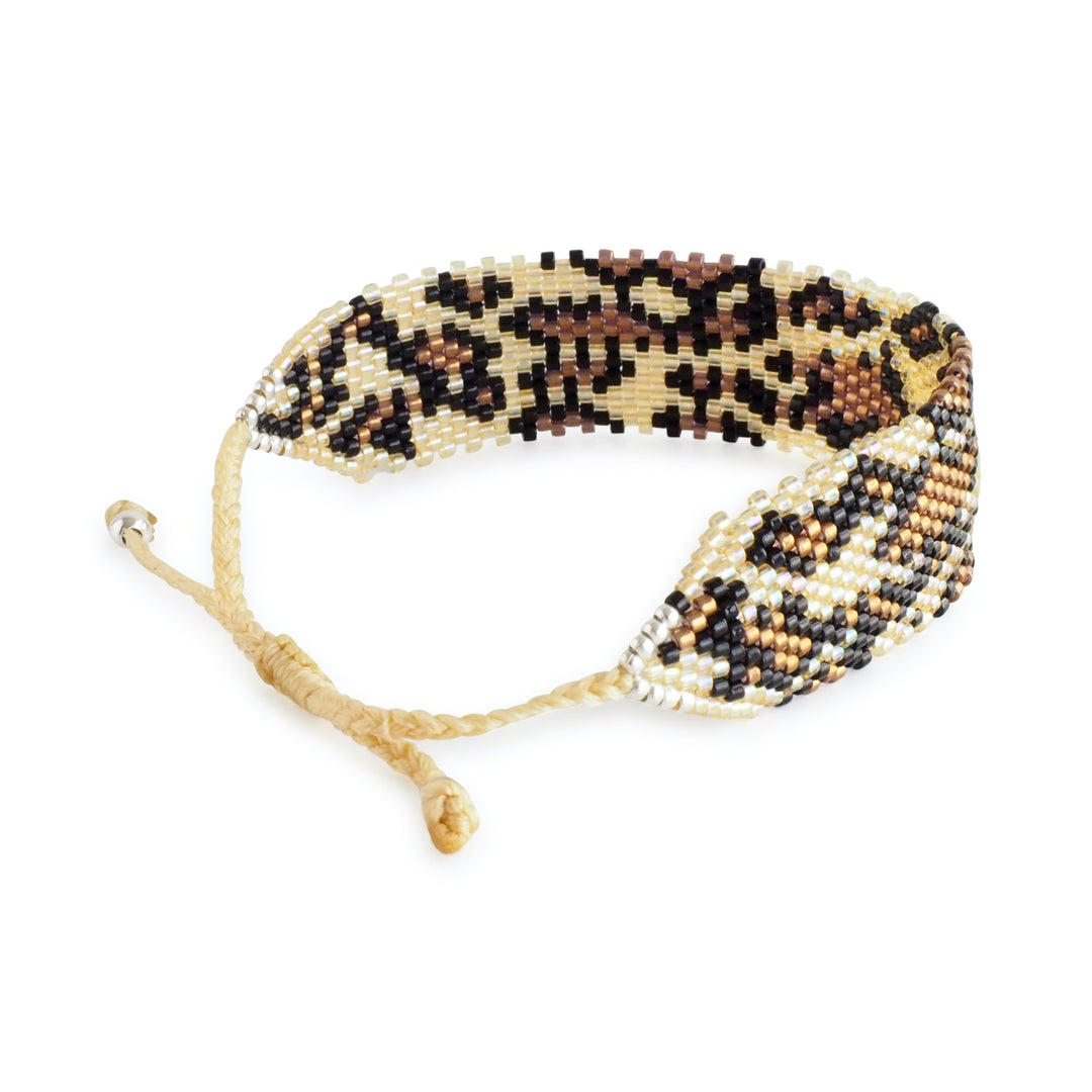 Wide brown Miyuki bead bracelet with leopard animal print design, handcrafted by Colombian artisans. Adjustable clasp, boho statement cuff.