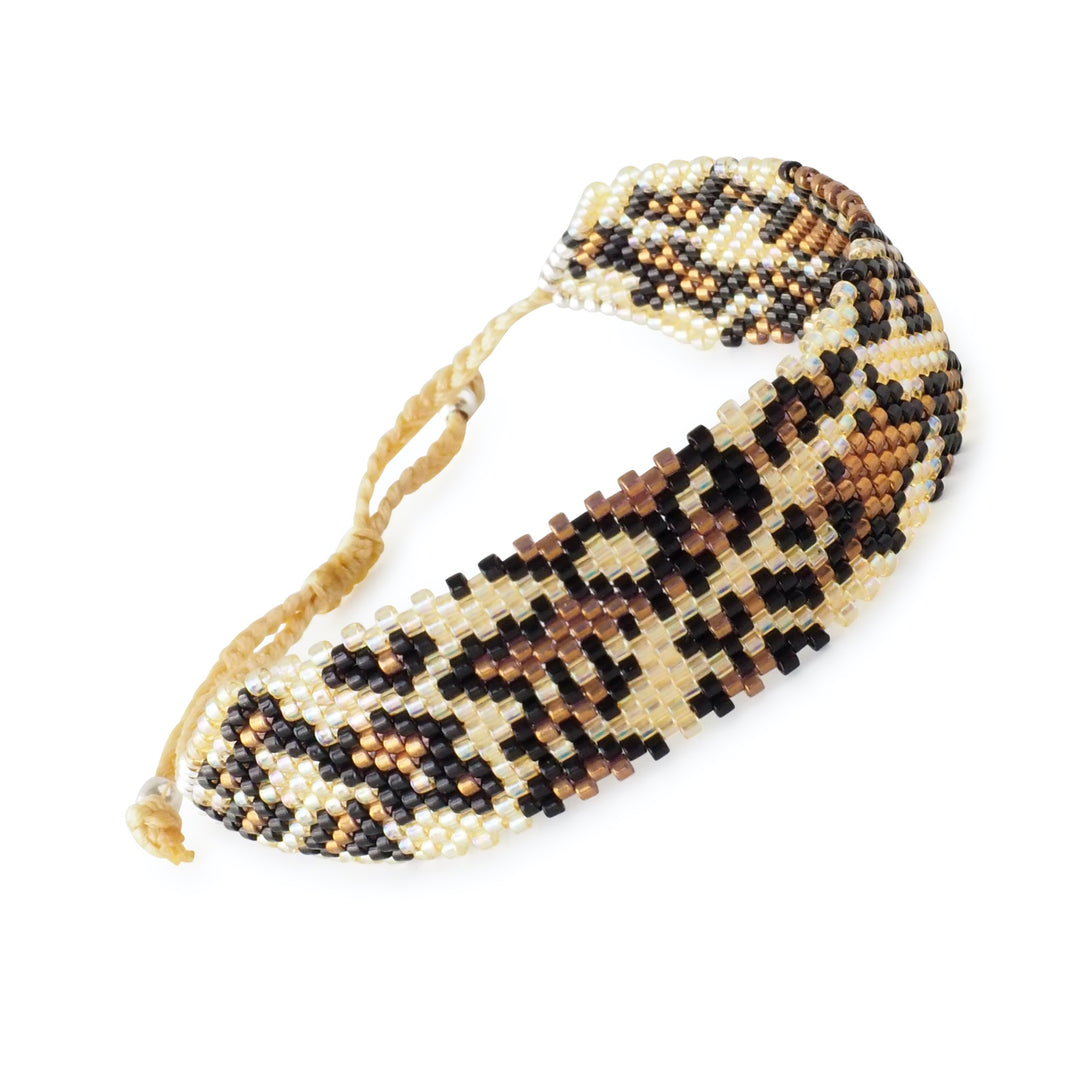 Wide brown Miyuki bead bracelet with leopard animal print design, handcrafted by Colombian artisans. Adjustable clasp, boho statement cuff.
