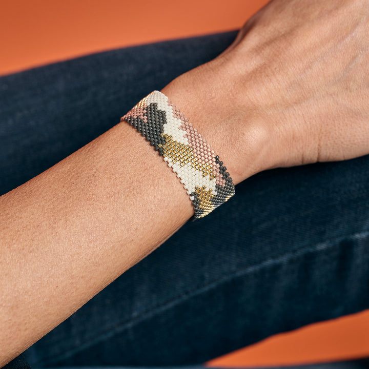 Handmade Leopard Miyuki beaded bracelet, pastel, grey, white and gold on a woman's wrist.
Colombian artisan jewelry, boho chic accessory.