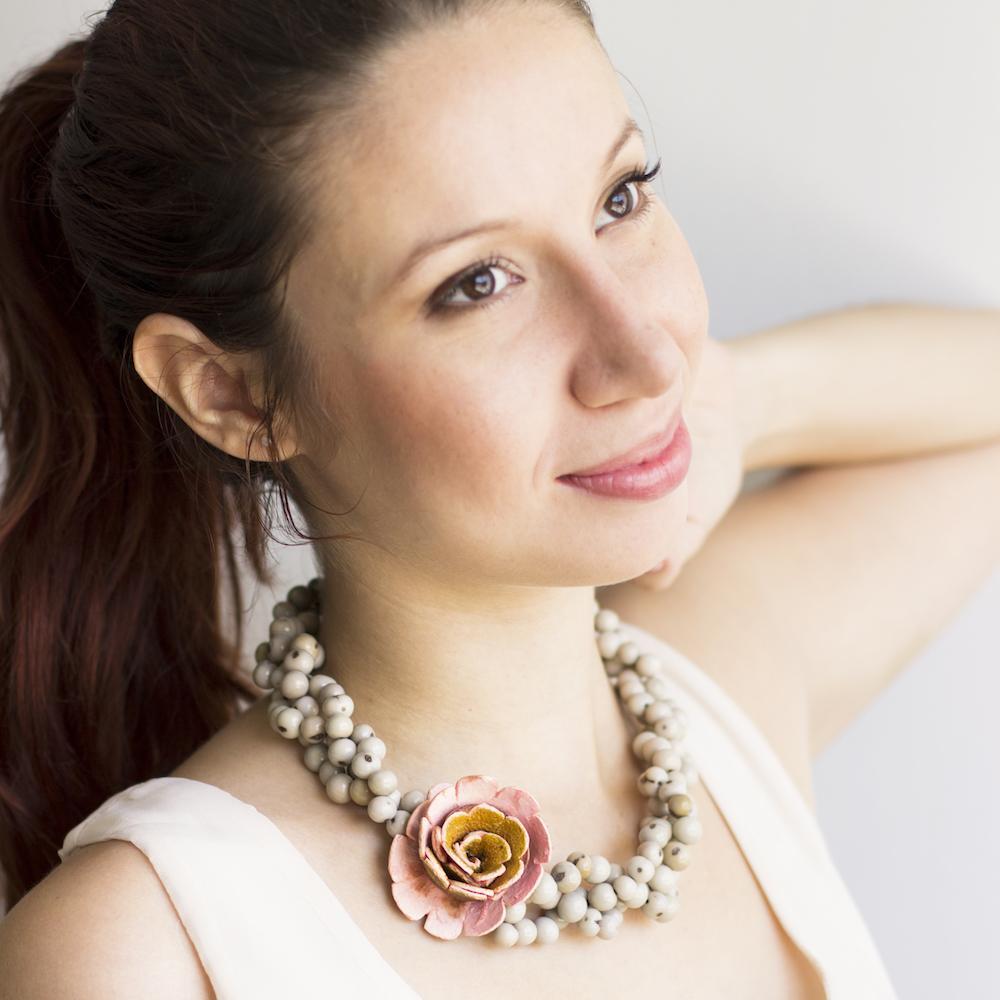 Flor Braided Necklace, with an orange peel flower. pale rose flower with sand acai beads on model